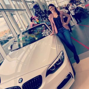 Alicia Linklater standing next to a BMW at Barrie Toy Tea fashion event